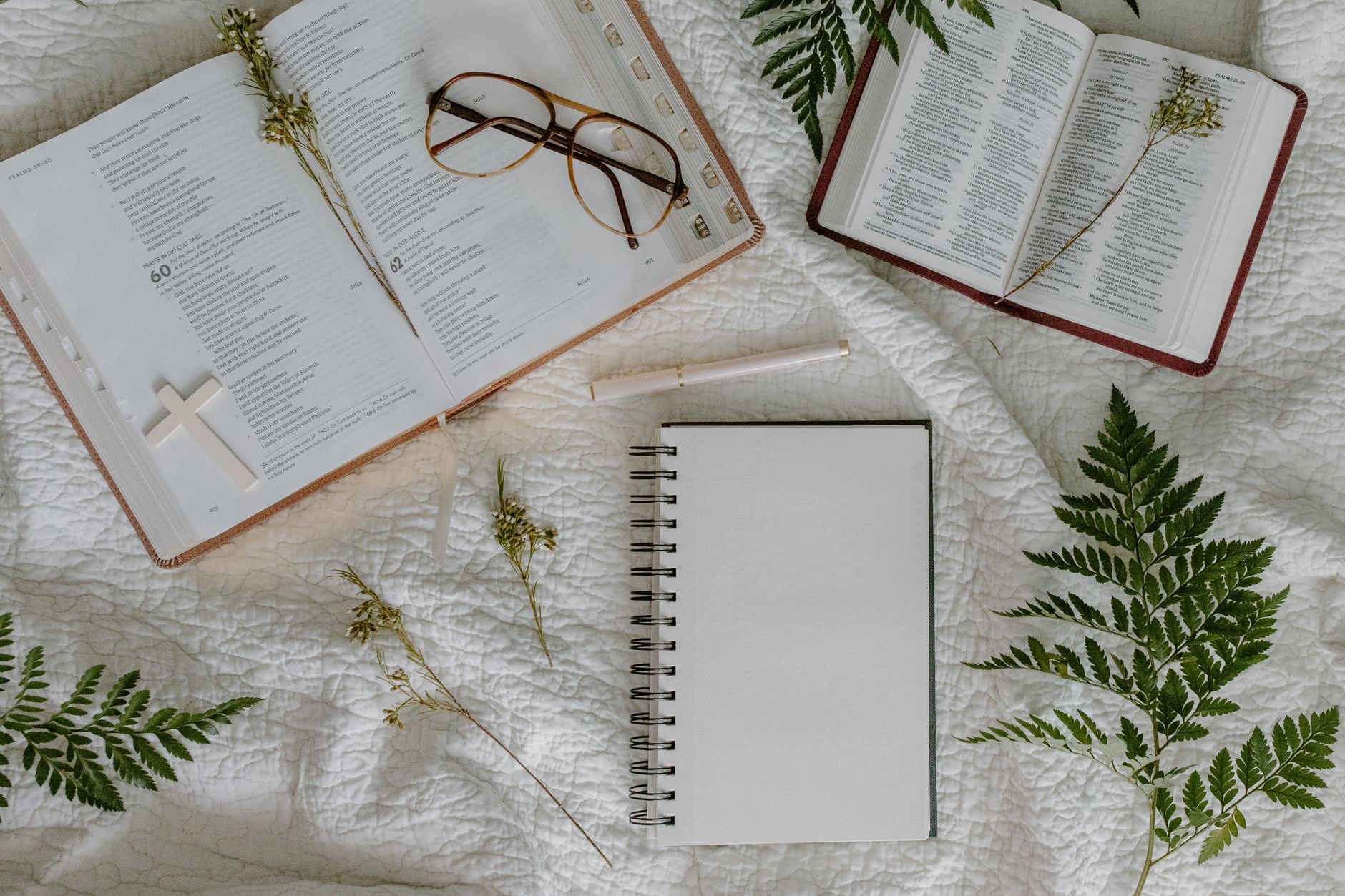Open Bibles and a notebook laid out on a warm welcoming desk